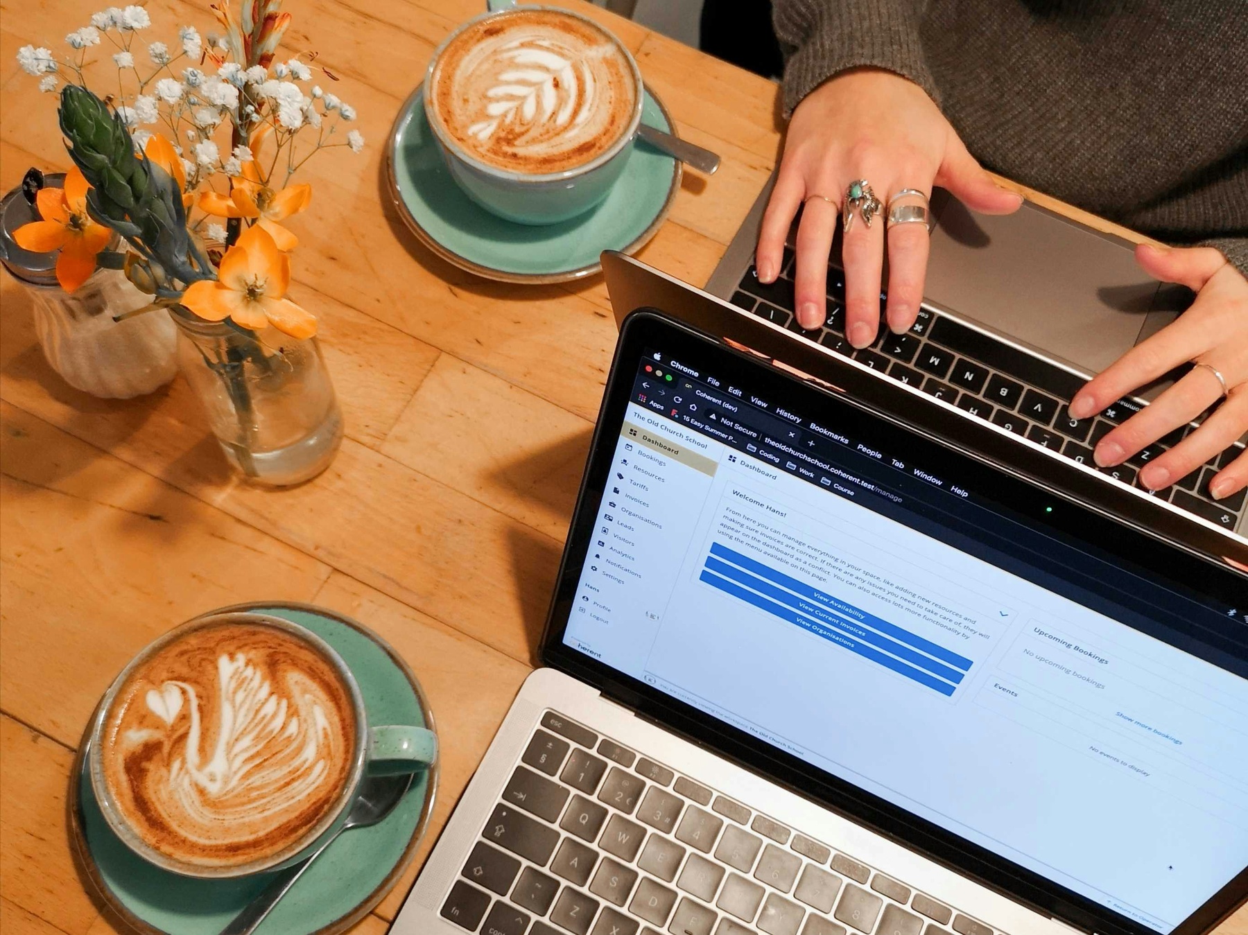 Two coffees on a desk next to a laptop. A conversation in progress.